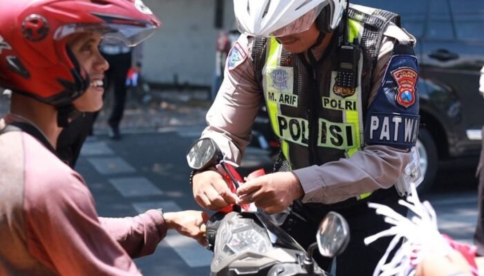 Satlantas Gresik Bagikan Bendera dan Pin ke Pengguna Jalan